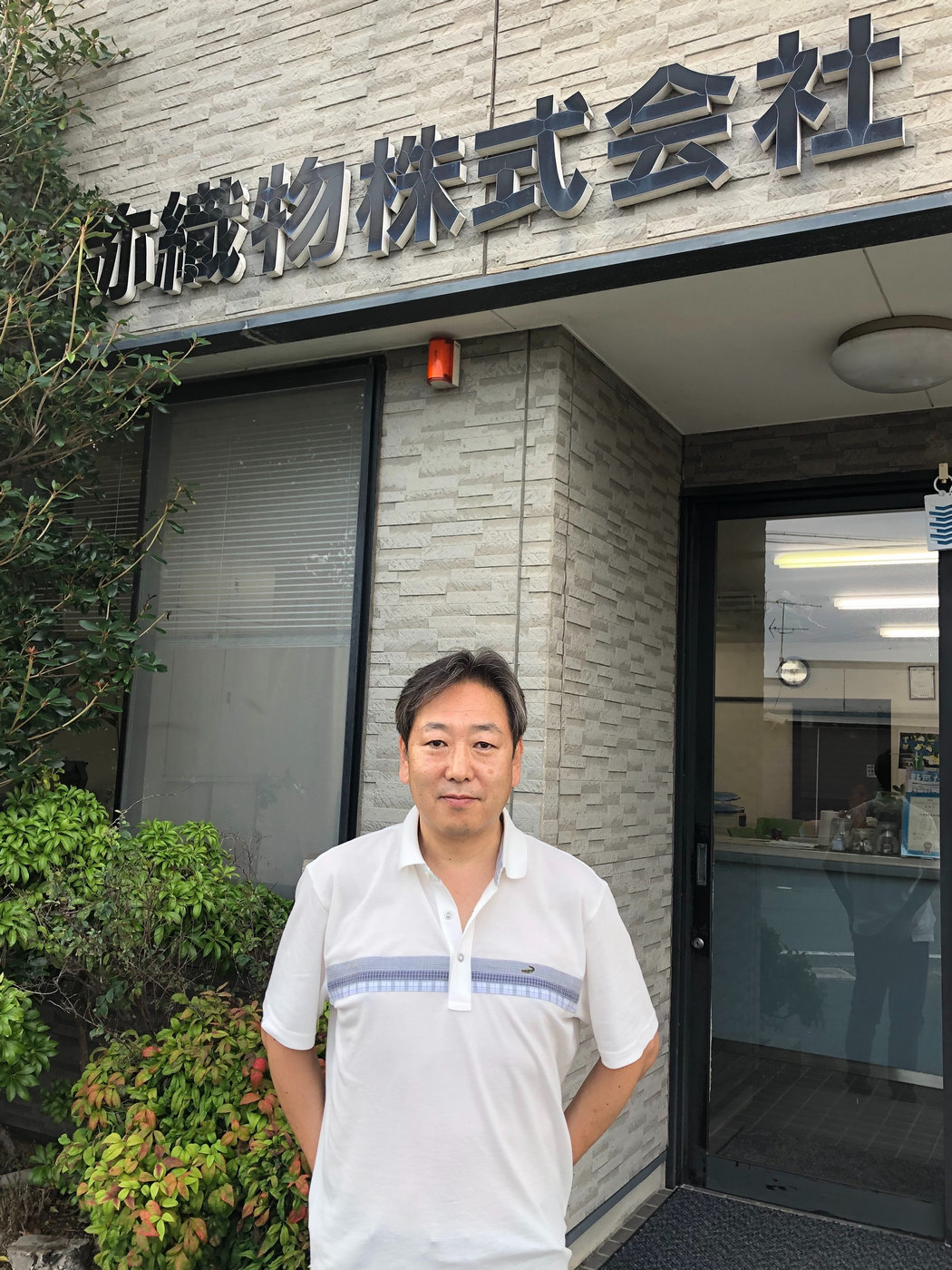 会社前に立つ代表